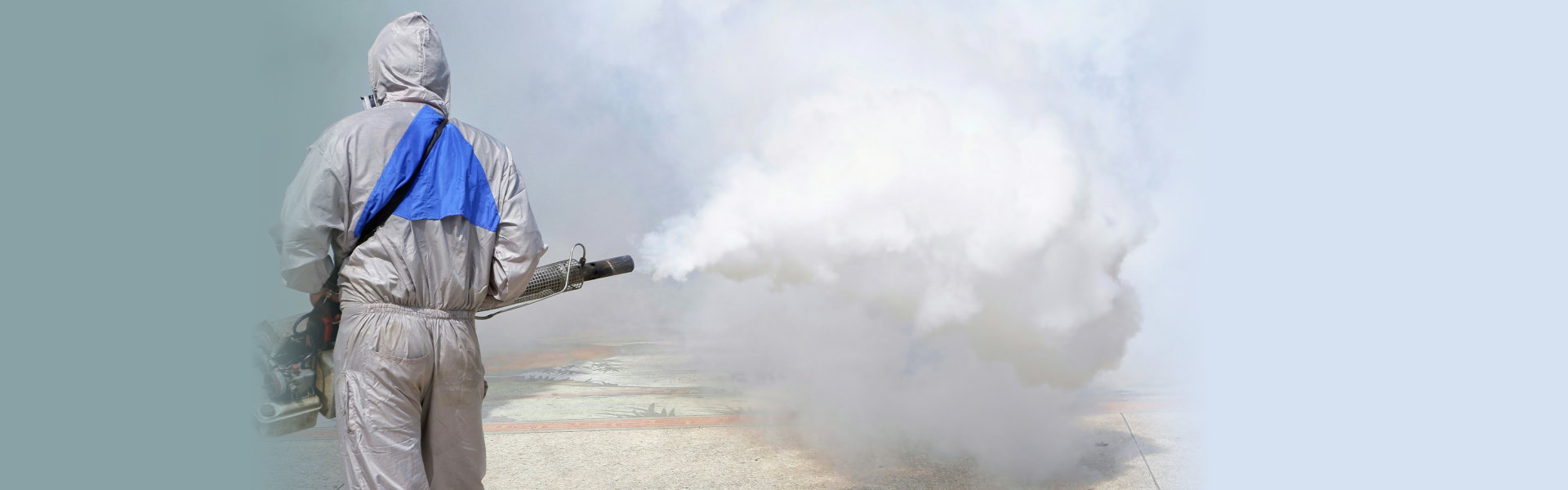 view of outdoor healthcare worker using fogging machine spraying chemical